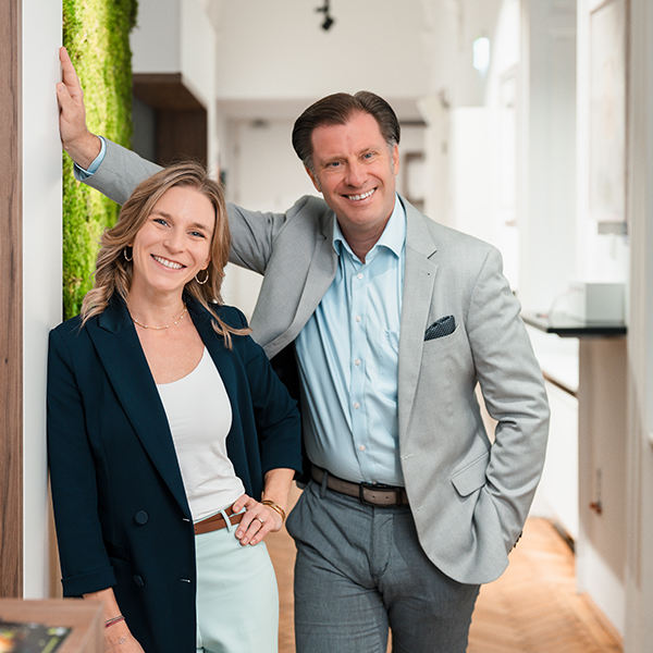 Andrea Pilecky und Roman Sartor stehend und lächelnd in die Kamera